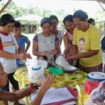 A group of marginalized women smiling and laughing together while attending a skills training workshop.