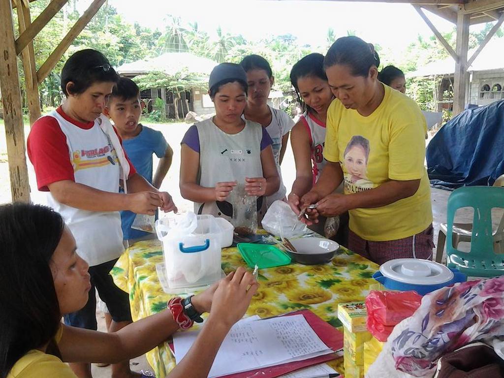 A group of marginalized women smiling and laughing together while attending a skills training workshop.