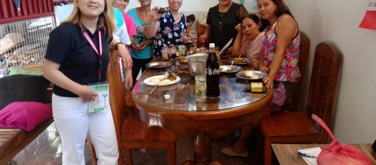 A photo of a group of people from different backgrounds and cultures working together. They are smiling and look happy and engaged.