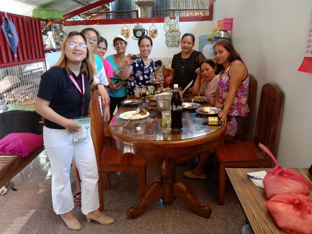 A photo of a group of people from different backgrounds and cultures working together. They are smiling and look happy and engaged.